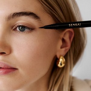Tube et applicateur Eyeliner Liquide dans un décor romantique